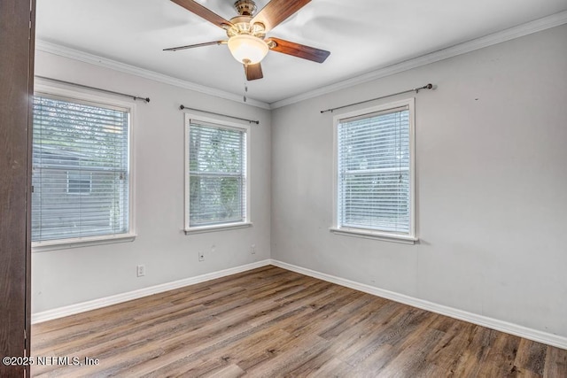 unfurnished room with ceiling fan, crown molding, baseboards, and wood finished floors