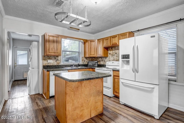 kitchen featuring wood finished floors, white appliances, a sink, and a healthy amount of sunlight