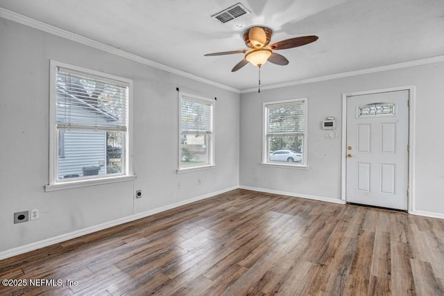 foyer entrance with baseboards, visible vents, a ceiling fan, ornamental molding, and wood finished floors