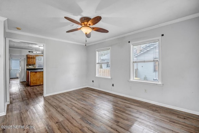 spare room with dark wood-style floors, ceiling fan, ornamental molding, and baseboards