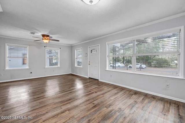 interior space featuring baseboards, wood finished floors, and crown molding