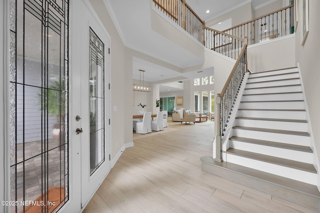 entryway featuring stairs, baseboards, wood finished floors, and crown molding