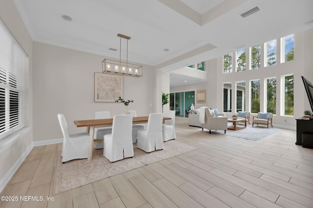 unfurnished dining area with wood finish floors, visible vents, a notable chandelier, and baseboards