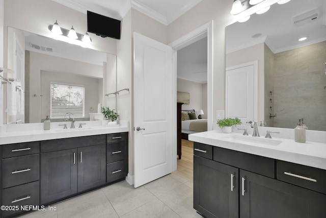 ensuite bathroom with crown molding, two vanities, and a sink