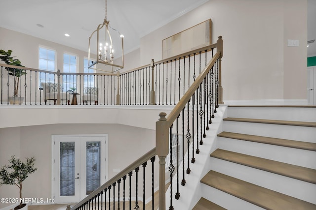 staircase featuring an inviting chandelier, recessed lighting, a high ceiling, and french doors