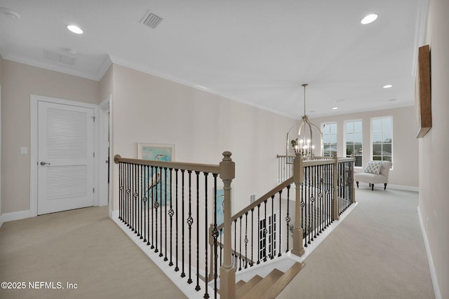 hall featuring carpet floors, visible vents, an upstairs landing, and an inviting chandelier