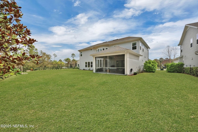 back of house featuring a lawn and a sunroom