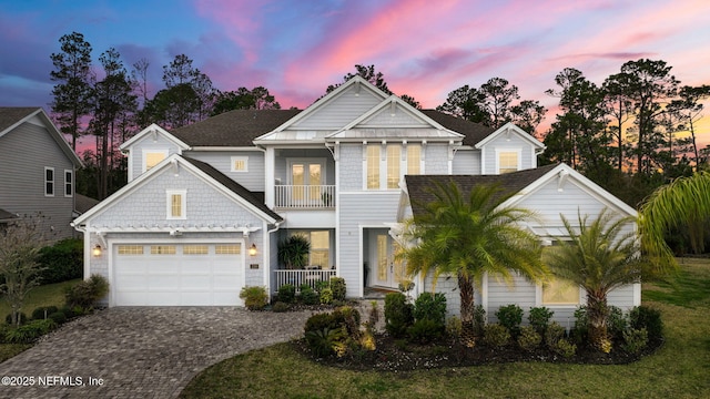 view of front of property with roof with shingles, decorative driveway, and a balcony