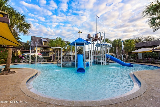 view of pool with playground community, a water slide, and a water play area