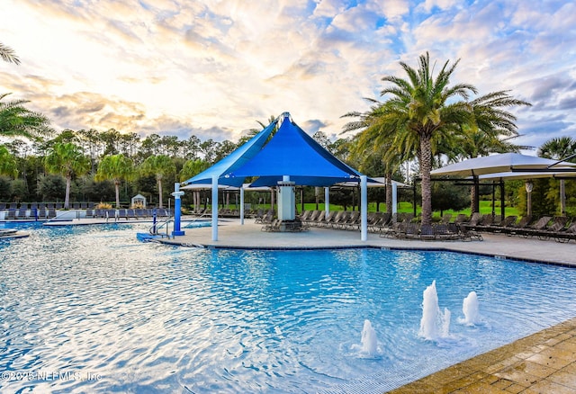 community pool with a patio area and fence