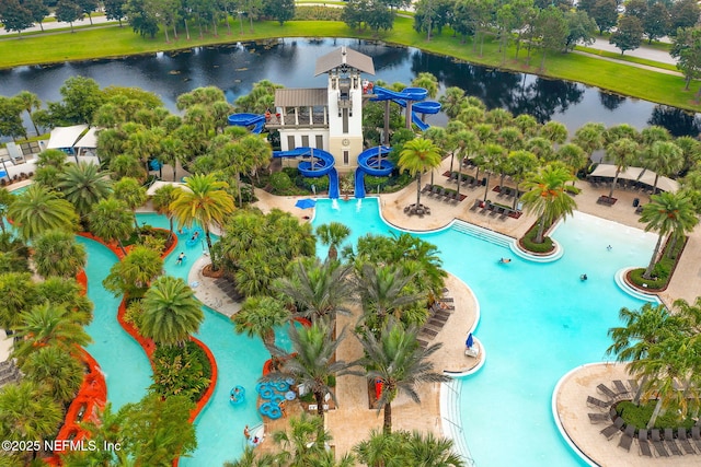 view of pool with a patio, a water slide, and a water view