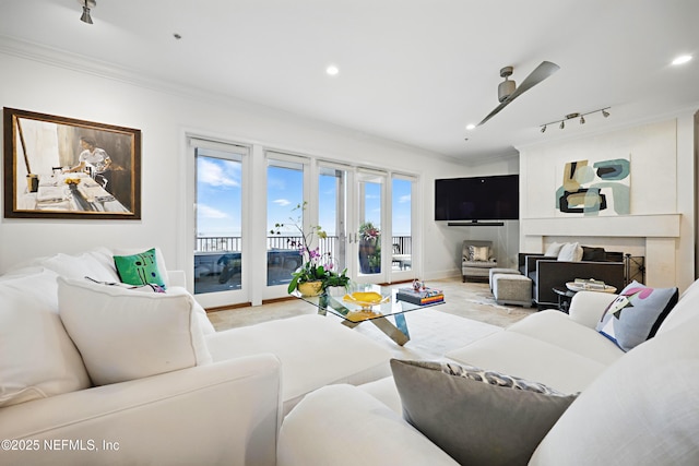 living area featuring recessed lighting, baseboards, track lighting, and crown molding