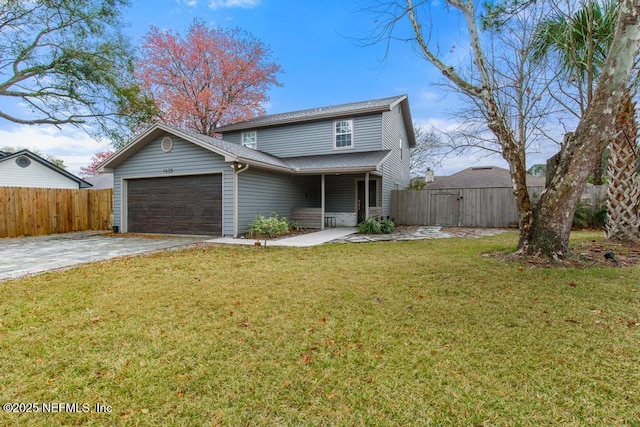 traditional-style house featuring a garage, a front yard, driveway, and fence