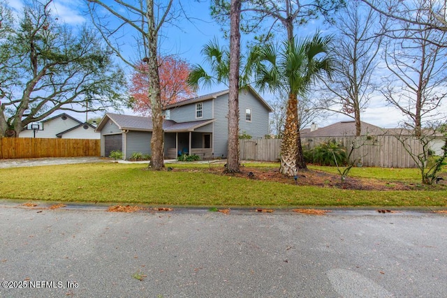 traditional-style home featuring a garage, a front lawn, and fence