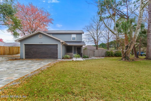 traditional home with a front lawn, decorative driveway, an attached garage, and fence