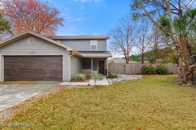 traditional-style home with a garage, a front yard, decorative driveway, and fence