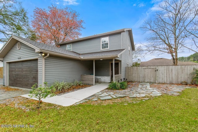 traditional-style home featuring a garage, a gate, fence, and a front lawn