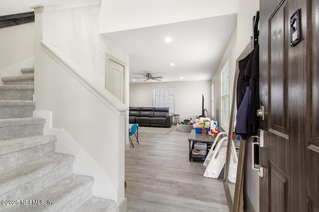 foyer entrance with stairs, a ceiling fan, recessed lighting, and wood finished floors