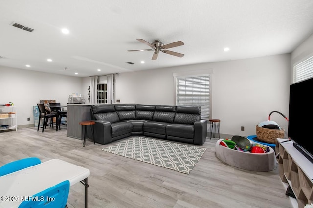 living area with light wood-type flooring, ceiling fan, visible vents, and recessed lighting