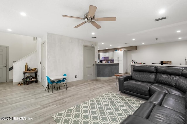 living area featuring recessed lighting, a ceiling fan, visible vents, stairs, and light wood-style floors