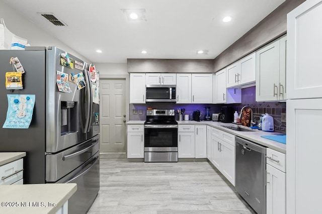 kitchen featuring stainless steel appliances, light countertops, visible vents, and a sink