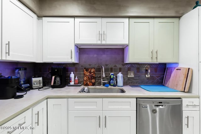 kitchen with white cabinets, light countertops, a sink, and stainless steel dishwasher