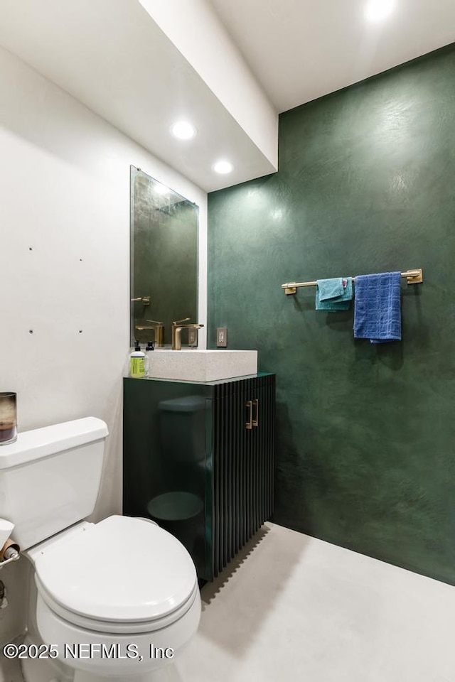 bathroom featuring toilet, recessed lighting, and vanity