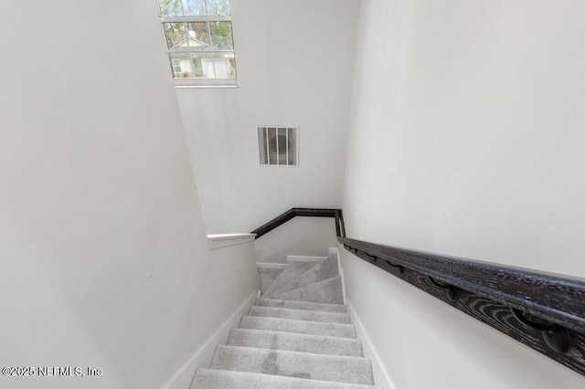 staircase featuring carpet, visible vents, and baseboards