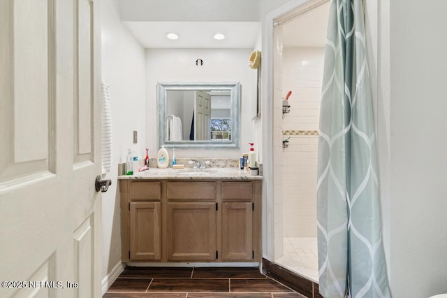 bathroom with recessed lighting, a shower stall, vanity, and wood tiled floor