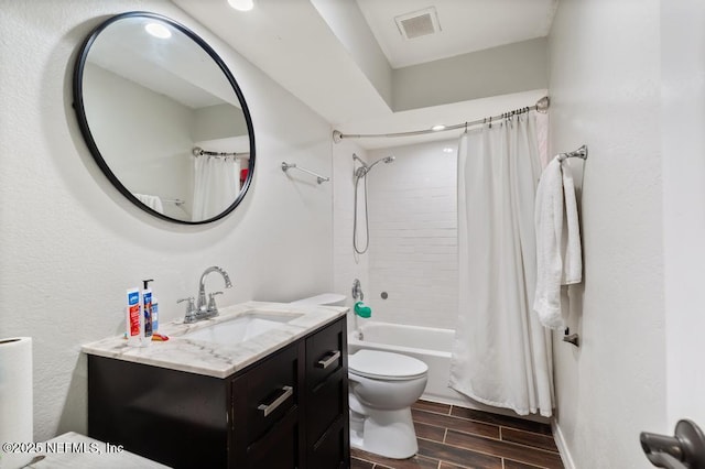 full bathroom featuring wood finish floors, visible vents, shower / bathtub combination with curtain, toilet, and vanity