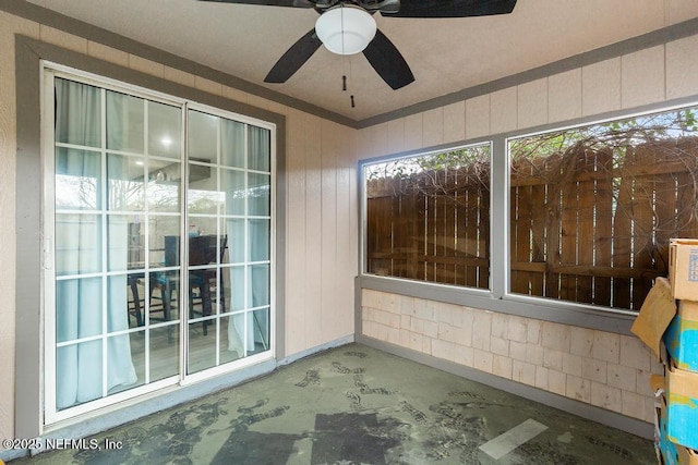 unfurnished sunroom featuring a ceiling fan