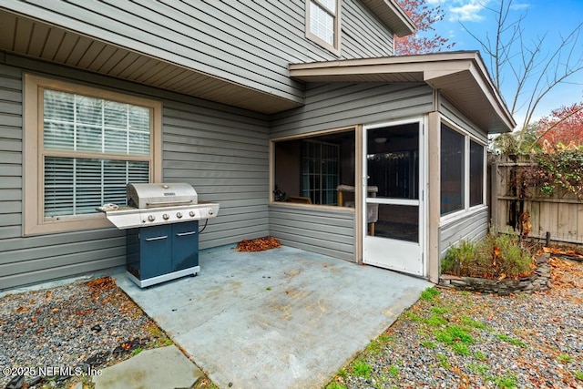 view of patio / terrace featuring a sunroom, fence, and grilling area