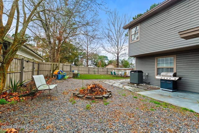 view of yard featuring cooling unit, a patio area, a fire pit, and a fenced backyard