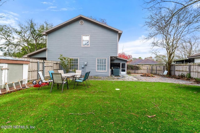 rear view of property featuring a lawn, a fenced backyard, and central air condition unit