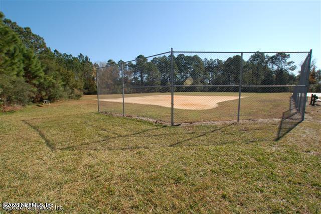 view of home's community with fence and a lawn