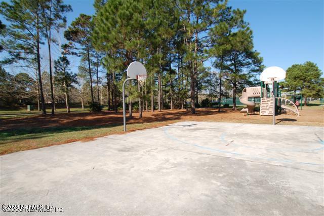 view of basketball court featuring playground community and community basketball court