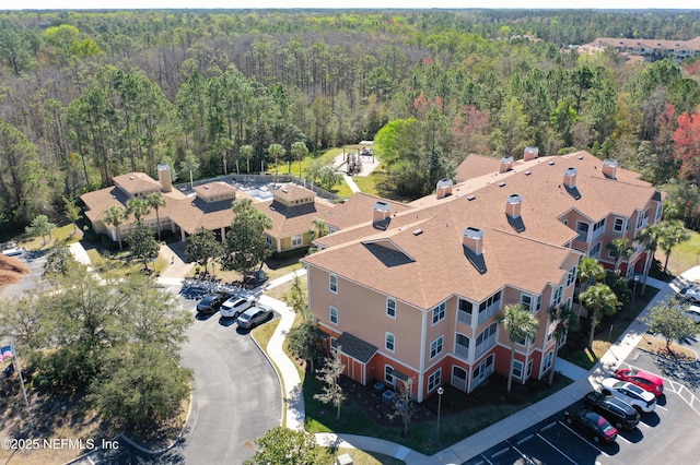 bird's eye view with a wooded view