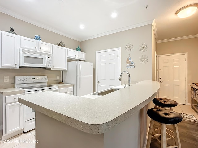 kitchen with white appliances, white cabinets, a kitchen breakfast bar, crown molding, and a sink