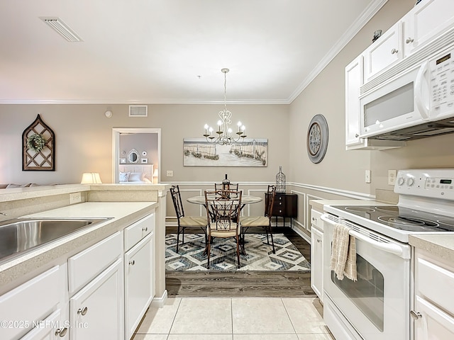 kitchen featuring white appliances, visible vents, crown molding, and light tile patterned flooring