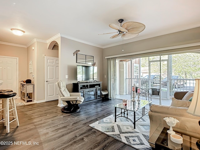 living room featuring baseboards, ornamental molding, and wood finished floors