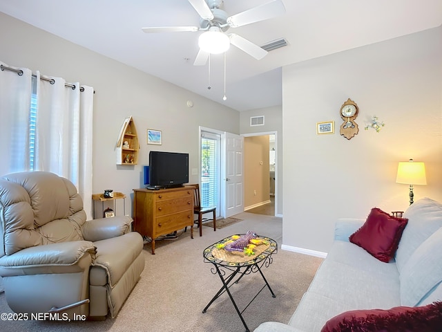 carpeted living area featuring a ceiling fan, visible vents, and baseboards