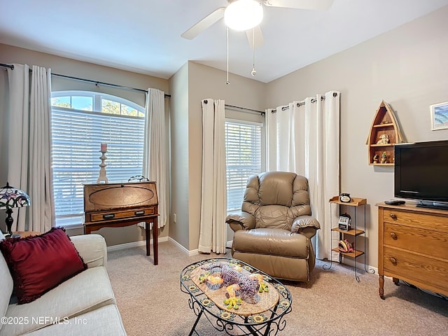 living area featuring carpet floors, ceiling fan, and baseboards