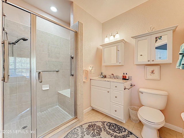 full bath featuring toilet, a stall shower, vanity, tile patterned flooring, and baseboards