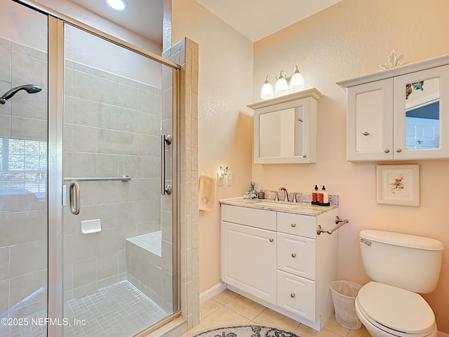 full bath with a stall shower, vanity, toilet, and tile patterned floors