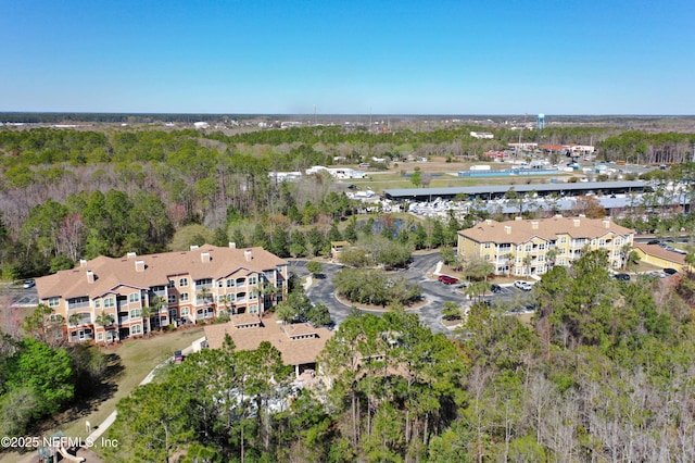 birds eye view of property featuring a view of trees