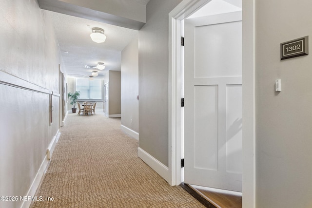 hall with carpet and baseboards