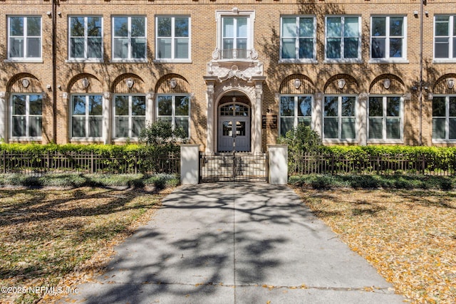 view of front facade with brick siding, a fenced front yard, and a gate