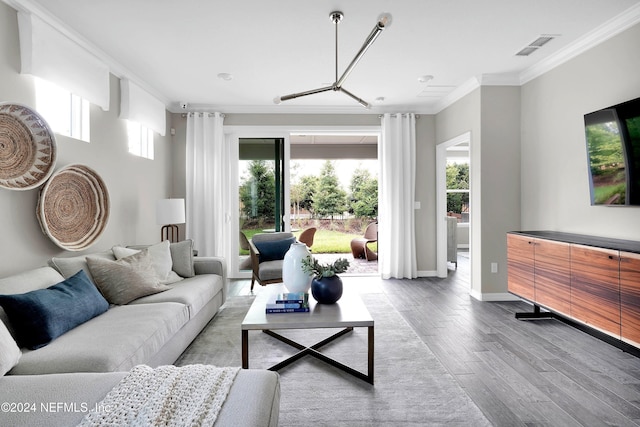 living area featuring ornamental molding, wood finished floors, visible vents, and baseboards