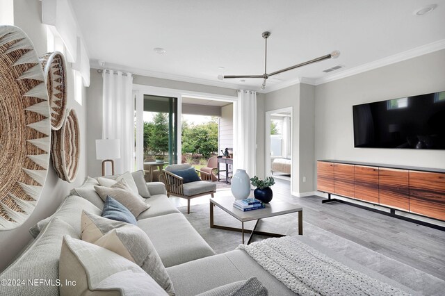 living room featuring baseboards, visible vents, ceiling fan, ornamental molding, and wood finished floors