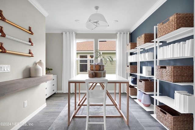 interior space with baseboards, crown molding, and wood finished floors